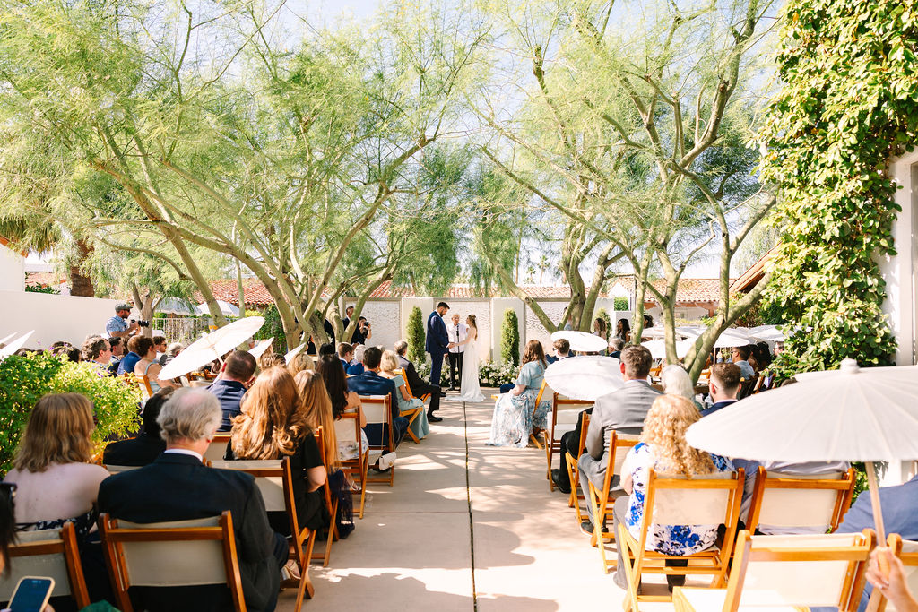 A look down the aisle as guests watch an alcazar palm springs wedding ceremony