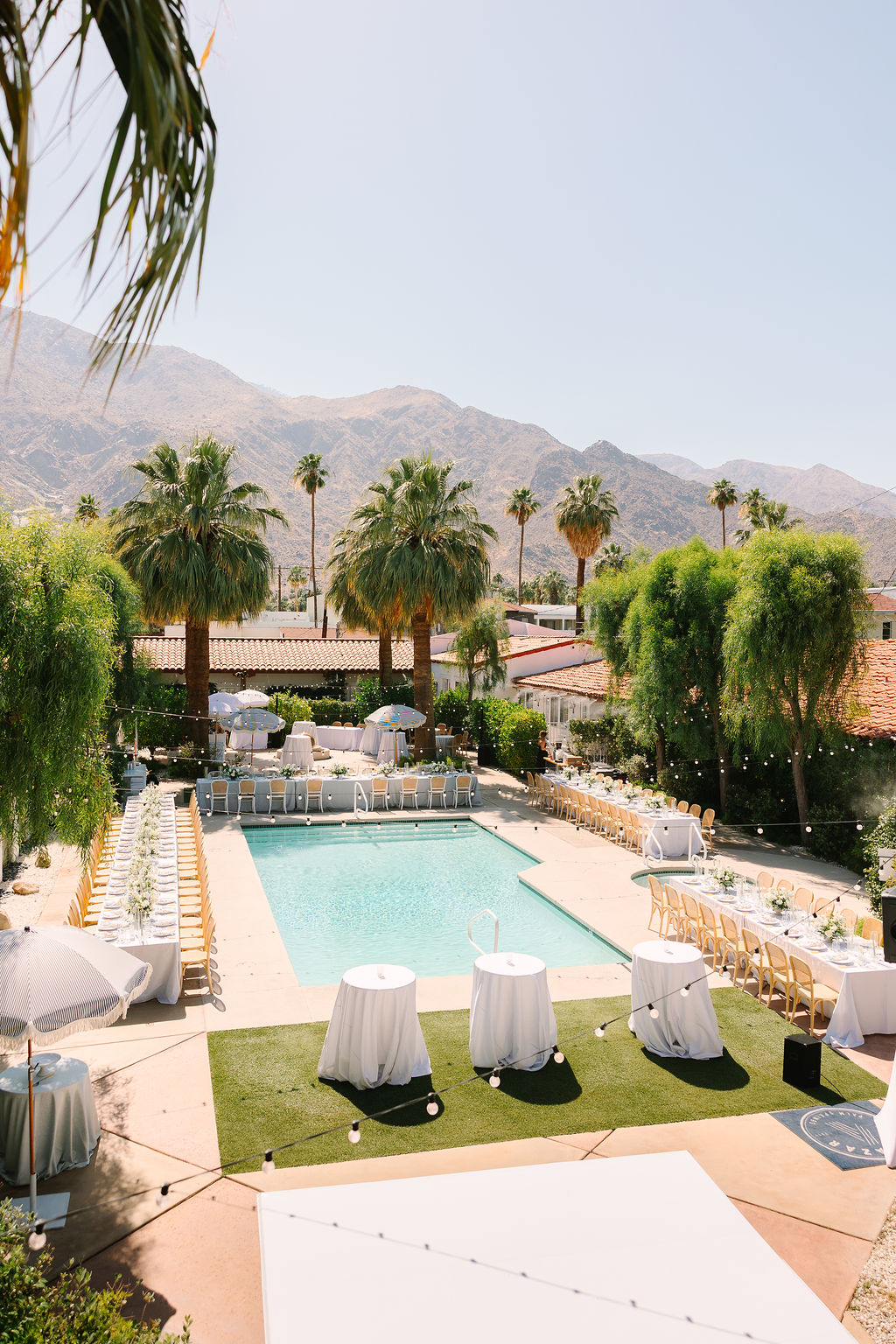 A look down from a balcony to a set up alcazar palm springs wedding reception around the pool
