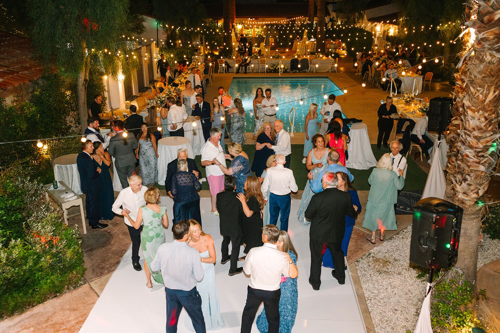 A look down onto an active alcazar palm springs wedding reception with dancers under market lights by the pool