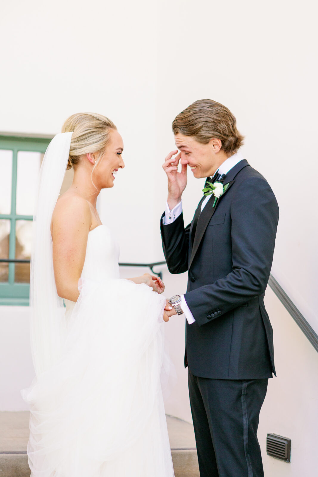 A groom wipes away tears during his first look with his laughing bride at their la quinta country club wedding