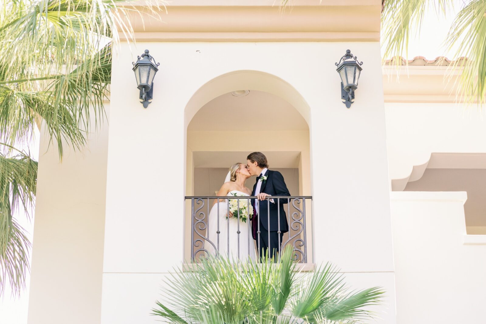 Newlyweds kiss on the balcony of the la quinta country club wedding venue