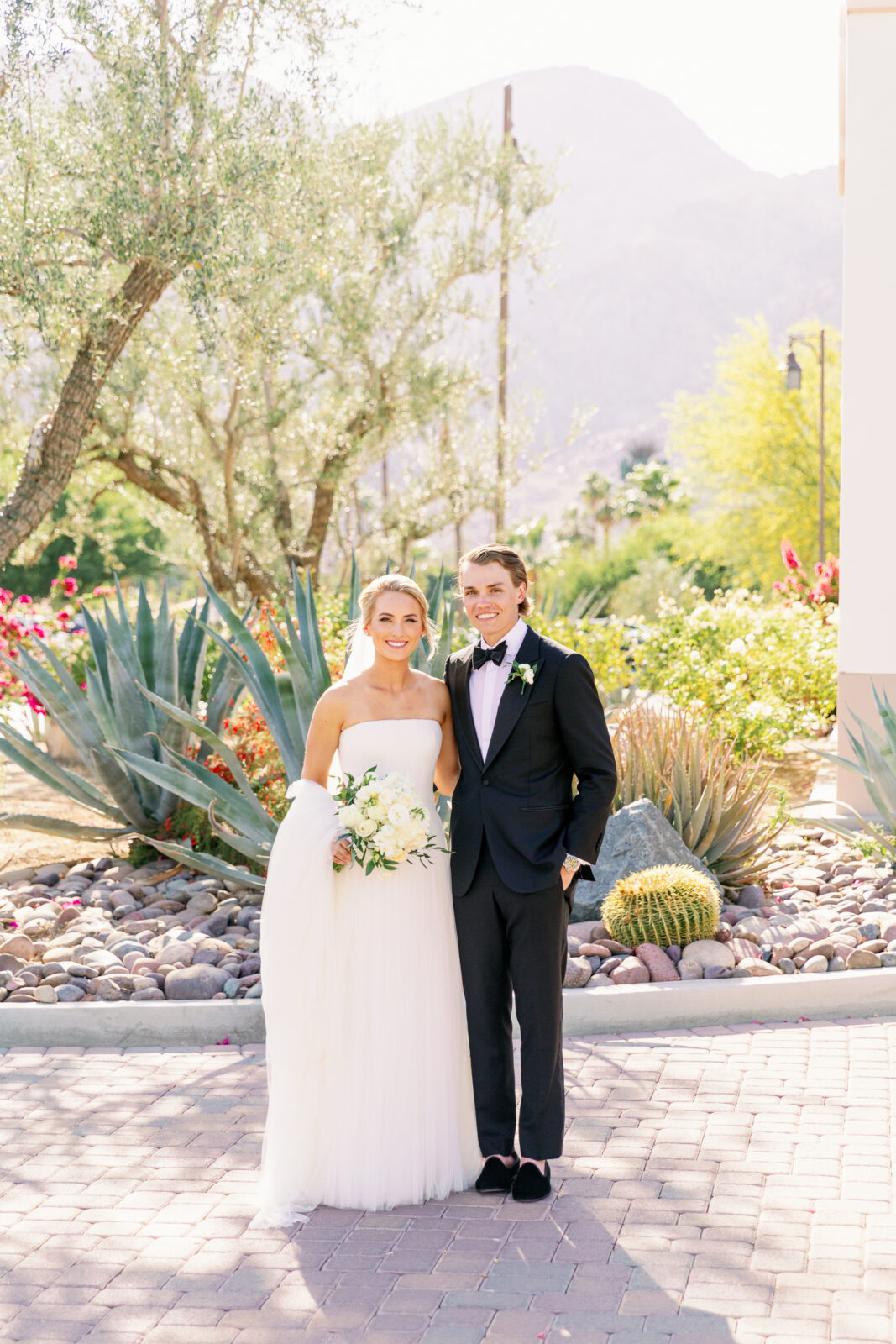 Newlyweds stand smiling with arms around each other on the la quinta country club wedding venue driveway