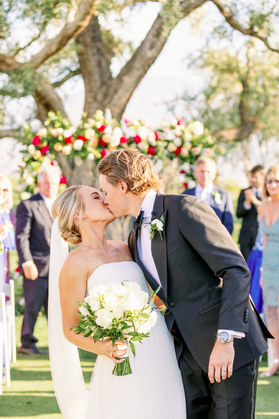 Newlyweds kiss in the aisle as guests look on to end their ceremony