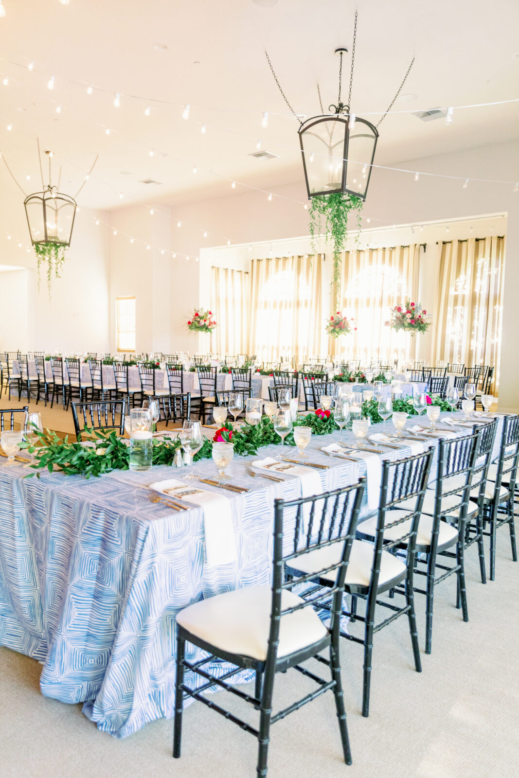 Details of a large wedding reception set up with long tables with blue linens
