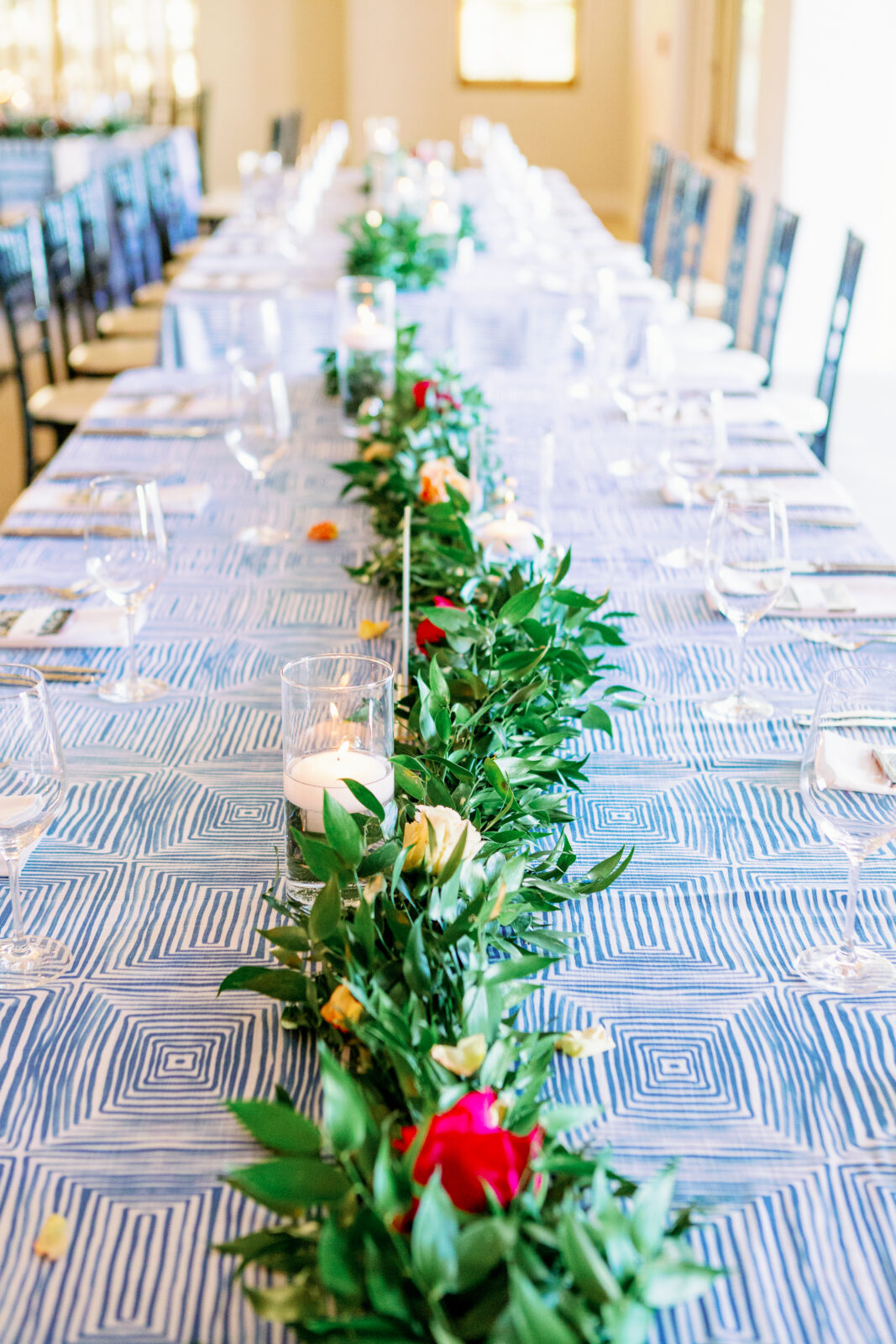 Details of a la quinta country club wedding reception table with a blue cloth and florals running the length