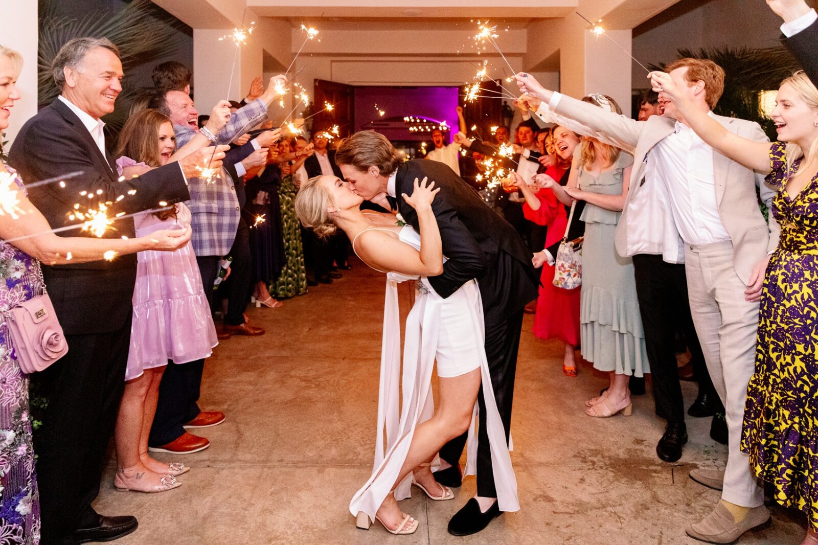 Newlyweds dip and kiss under a sparklers exit at their la quinta country club wedding
