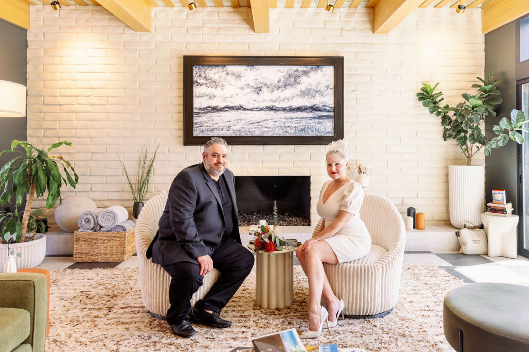 Happy newlyweds sit in chairs in a beautiful living room