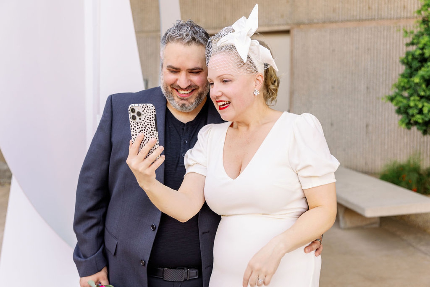 Happy newlyweds laugh while on facetime outdoors