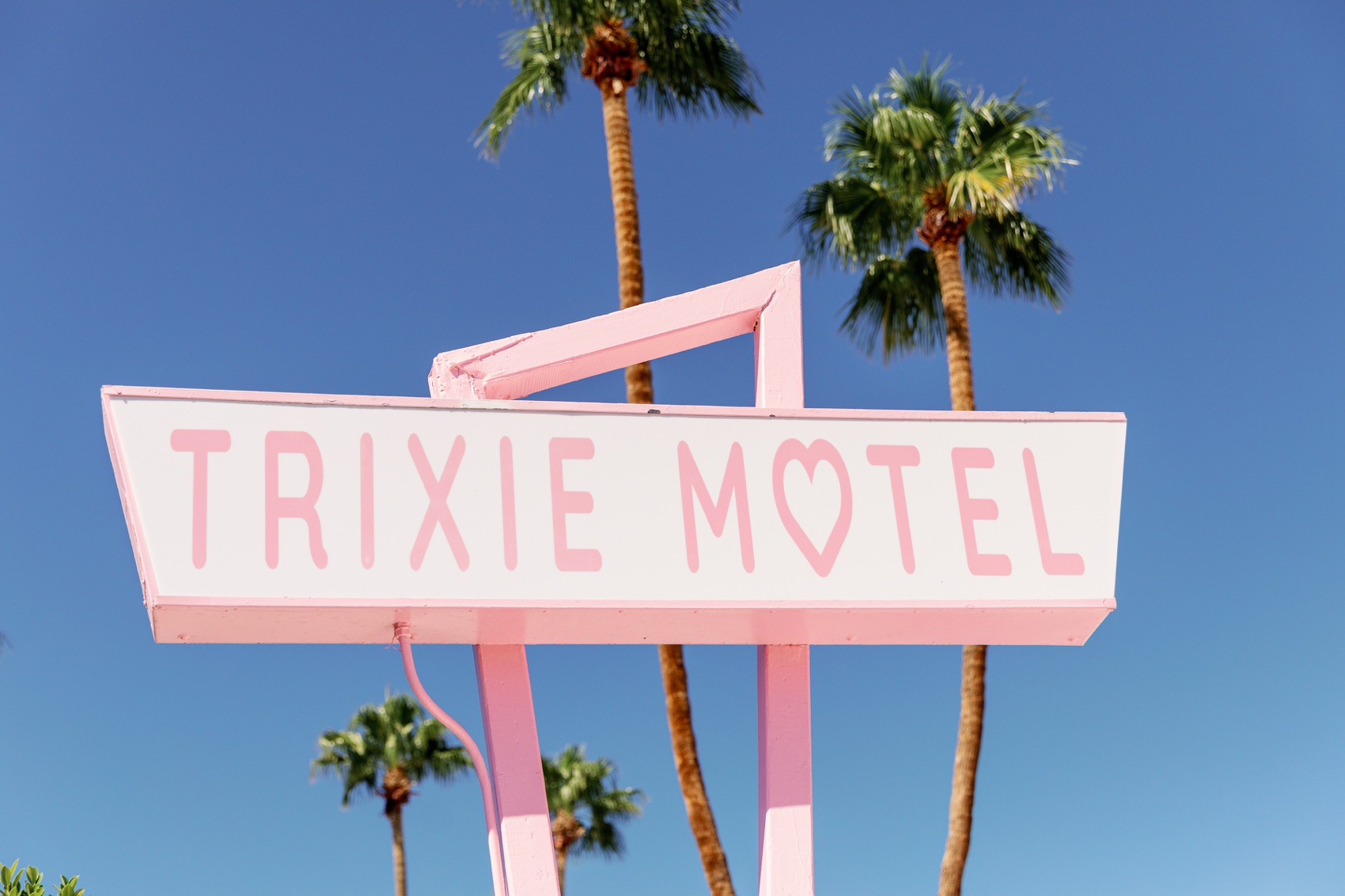 Details of the vintage style trixie motel palm springs sign with palm trees