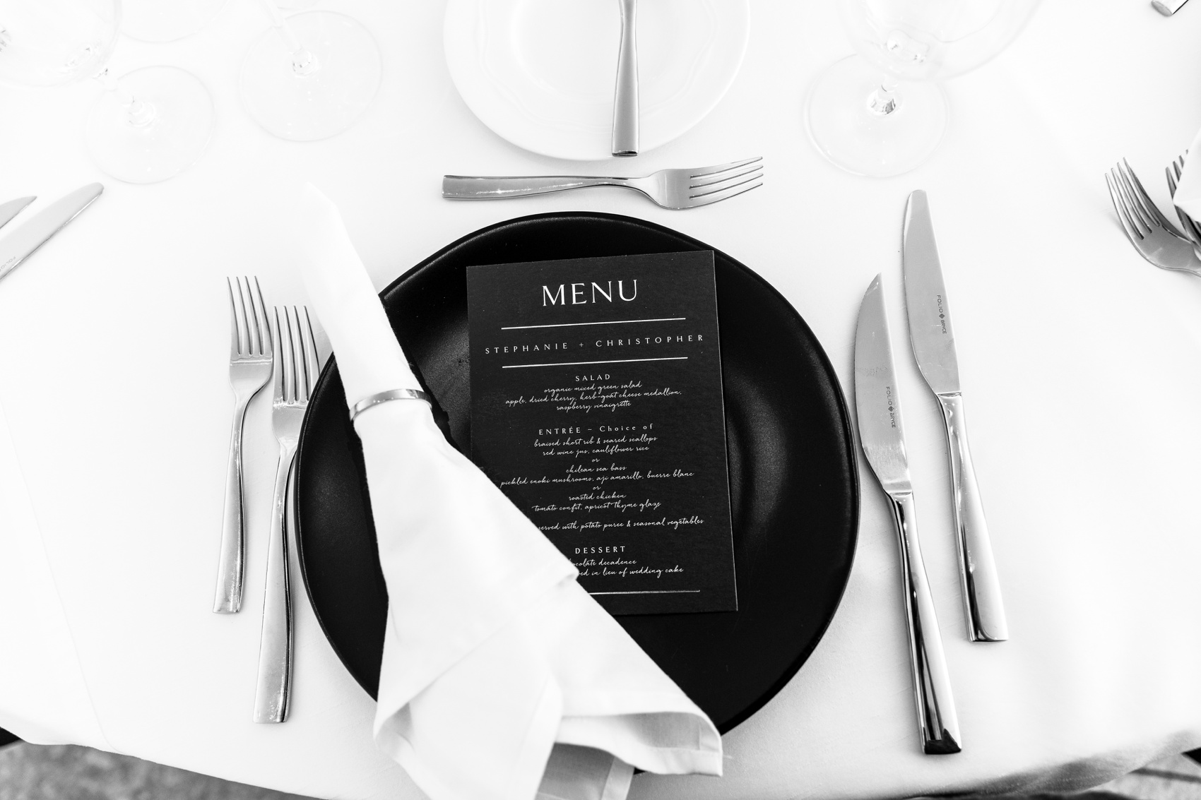 Details of a black and white wedding reception place setting with a menu