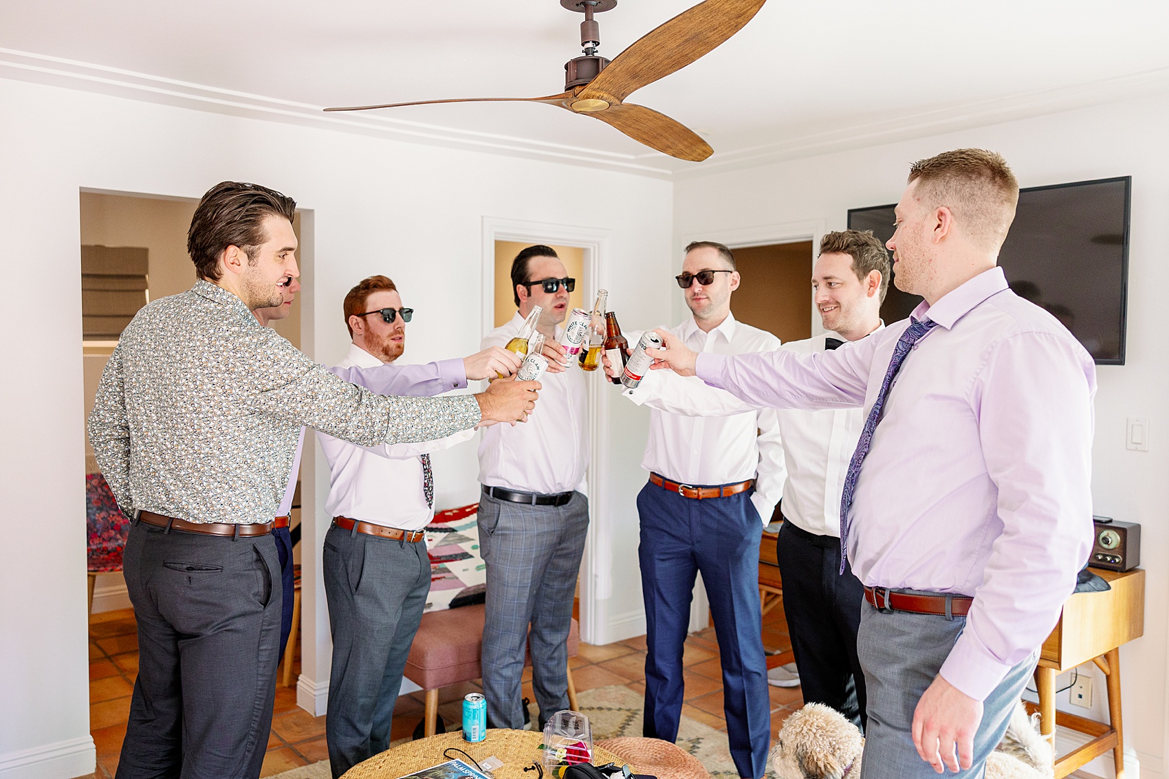 A groom toasts with his groomsmen while getting ready