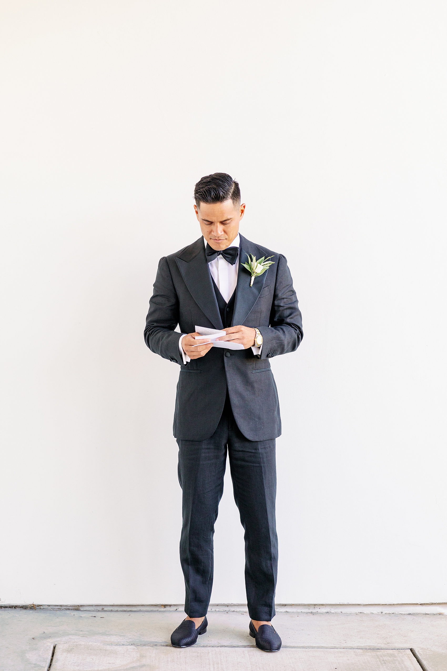 A groom reads his vows while getting ready