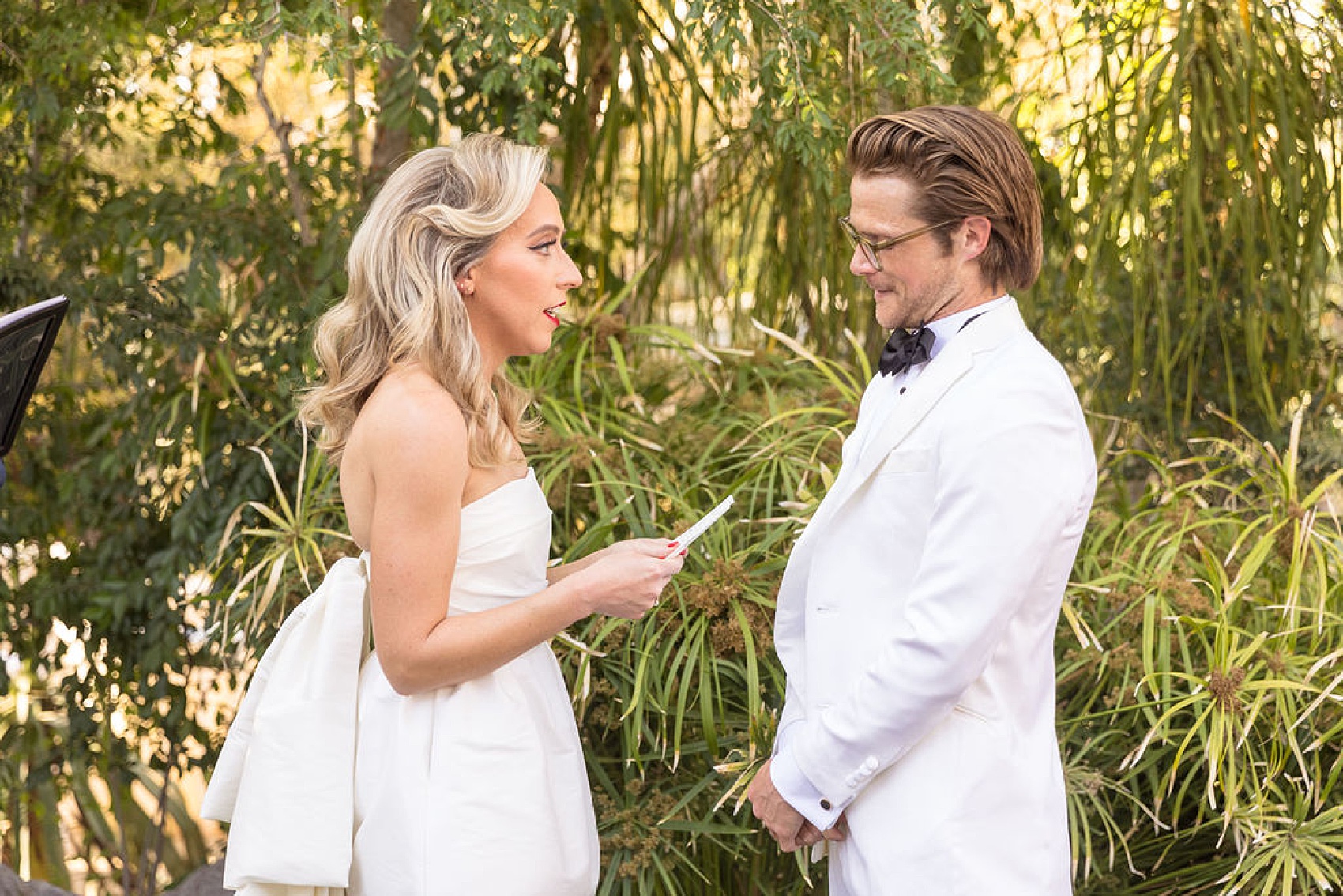 A bride reads her vows to her groom in their garden ceremony
